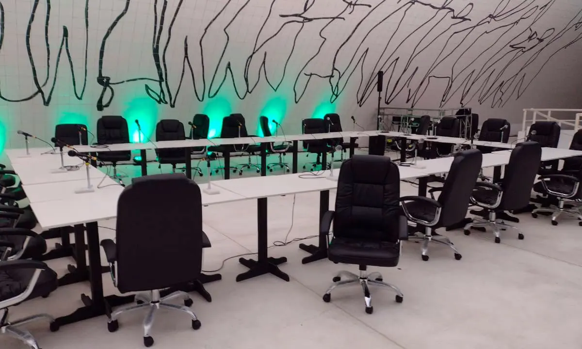 Sala com cadeiras executivas pretas e mesa pranchão individual